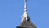 Original Spire:  White spire on peak of roof with the blue-sky background.