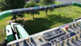 View from lift, showing controls, with the boom in the background and trees and grass below.