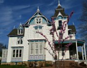 Large white Victorian styled house with blue and grey detailing and black shingles