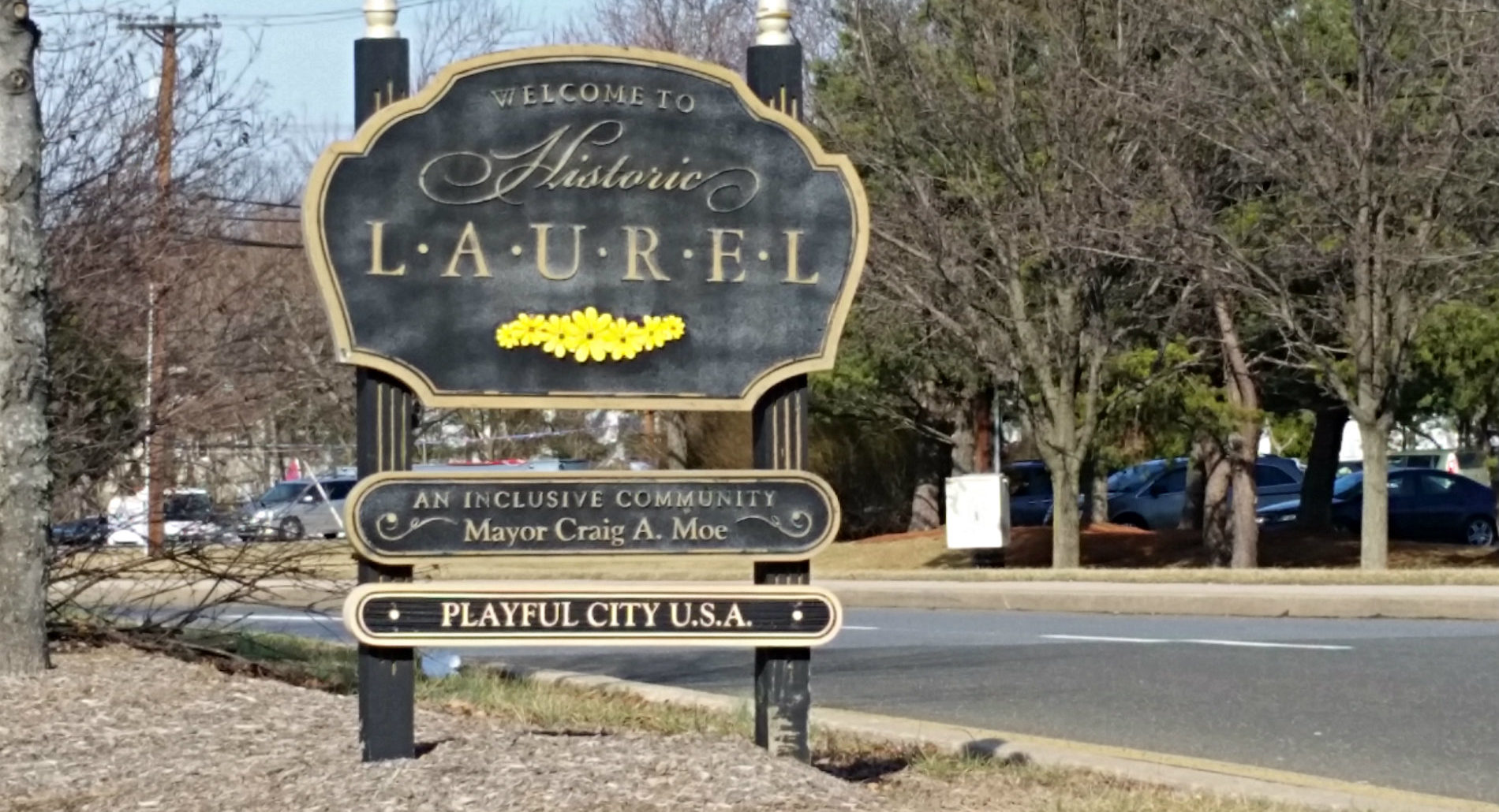 Large exterior black and beige sign that says welcome to historic laurel, an inclusive community, playful city USA